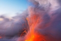 مصوِّرون شجعان يخاطرون بحياتهم لإلتقاط صور مدهشة لحمم بركانية تزحف إلى المياه في هاواي