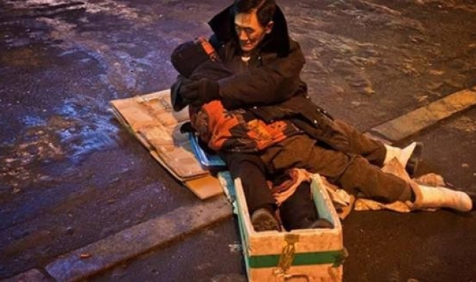 تحول إلى نموذج للحب الحقيقي ...بالصور: صيني يعانق زوجته المتوفاة ساعتين في الشارع