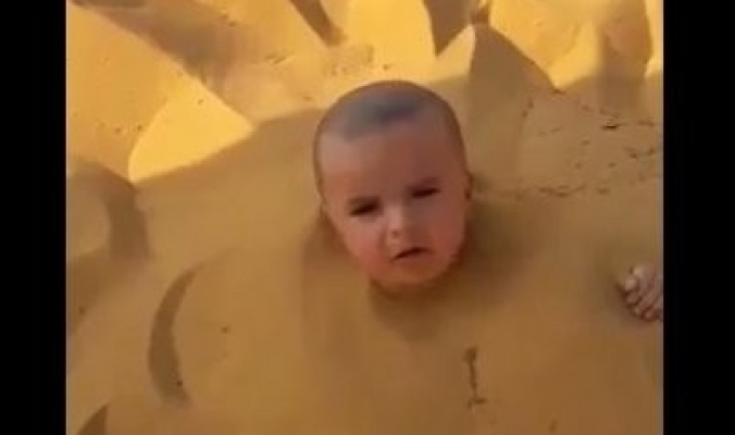فيديو مؤلم لرضيع سعودي دفنه والده في الرمال ثم وقف يتهكم على بكائه..