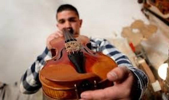 شاب فلسطيني يمتهن صناعة الكمان ويسوقها عالمياً