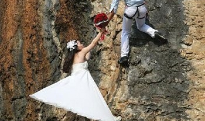 زوجان يتسلقان جبلا لالتقاط أخطر صور زفاف فى العالم
